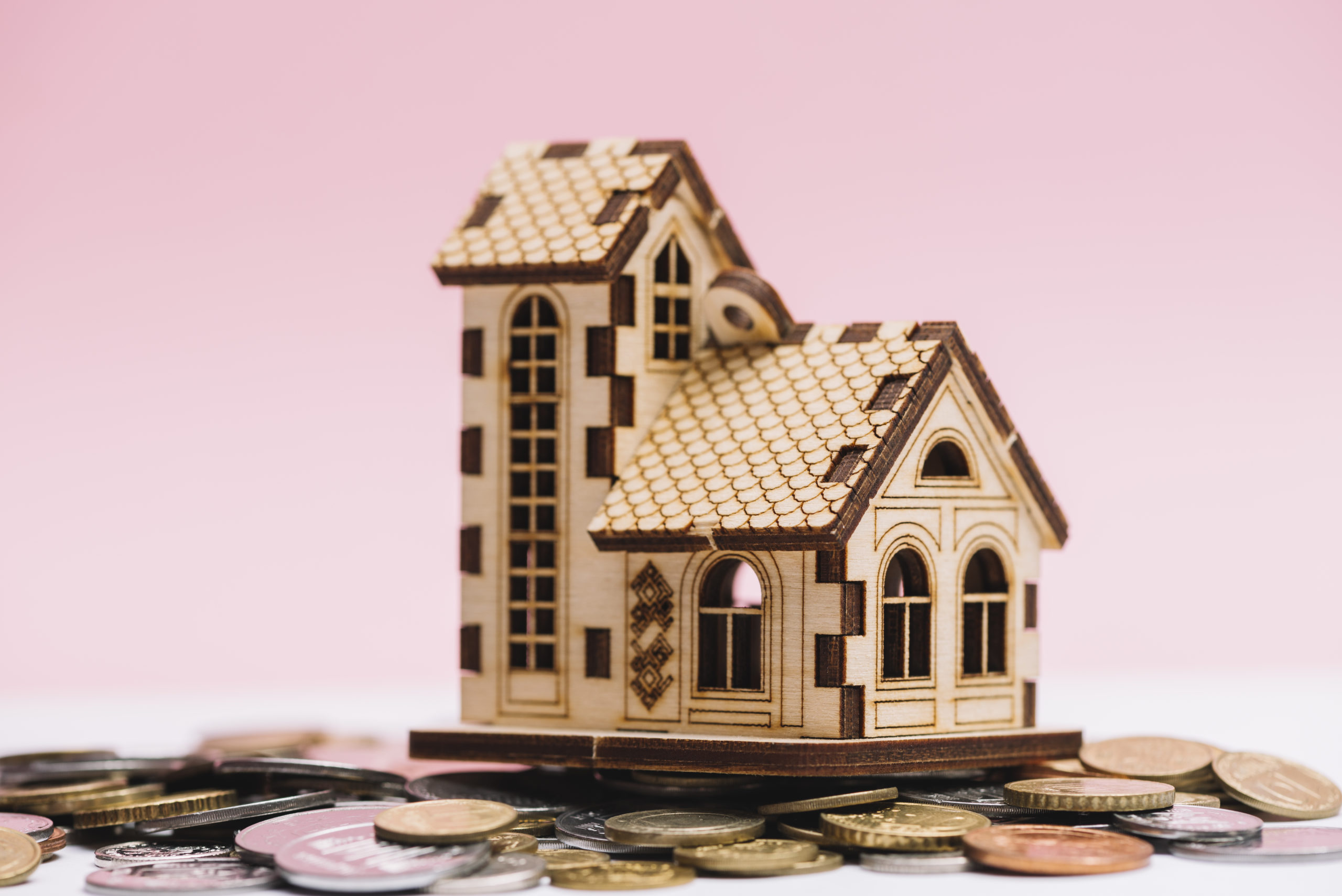 house-model-coins-front-pink-background
